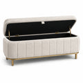 Banco de tela beige con estructura de metal dorada y almacenamiento